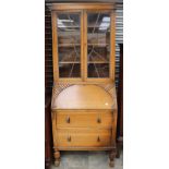 An early 20th Century oak bureau bookcase, with a glazed upper section, fall front and two drawers,