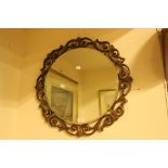 A reproduction gilt framed circular wall mirror, with a scroll carved edge,