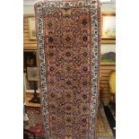 Long red and cream rug with geometric floral pattern