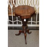 A mid Victorian rosewood ladies work table, the octagonal top raised on an octagonal column,