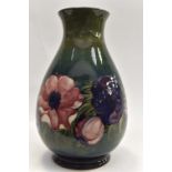 A signed Moorcroft baluster vase, impressed Moorcroft. Green ground "anemone" - height 39 cms, 15.