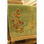 A contemporary woollen green ground floral patterned runner rug