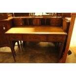 An Edwardian mahogany desk with pigeon holes, leather insert to top, three drawers,