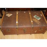 An early 20th Century canvas and wood bound travelling trunk,