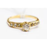 A solitaire diamond ring with shoulders set with three diamonds, total weight approx 0.