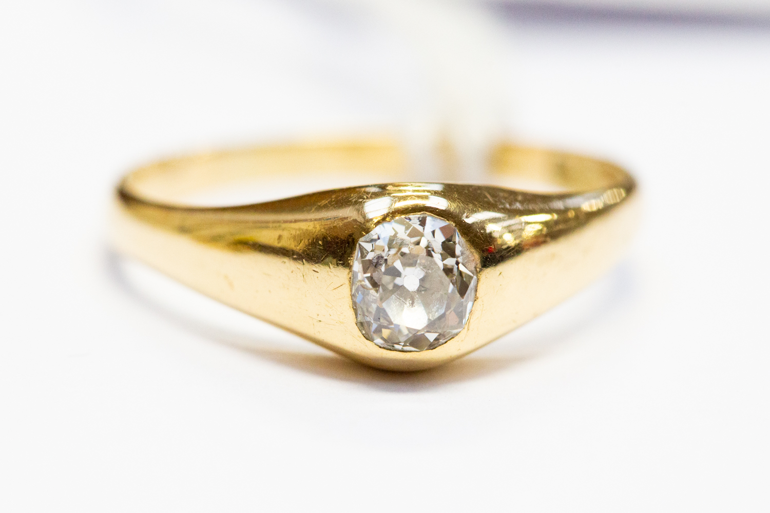 A diamond solitaire 18ct gold ring, the oval rub-over set old cut diamond approx 0.