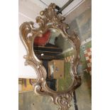 A large Rococo style gilded wooden mirror, in the asymmetrical form,