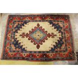 A 20th Century hand knotted woollen rug, cream ground, red and blue patterned border,