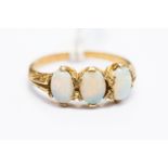 A 9ct. gold and opal ring, set row of three oval cabochon opals, shank hallmarked for 9 carat gold.