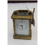 A late 19th Century brass cased carriage clock, having a white enamelled dial, black Roman numerals,