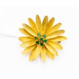 Yellow metal brooch stamped 750, in the form of a flower set with emeralds,