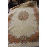 Large cream rug with border and central floral pattern