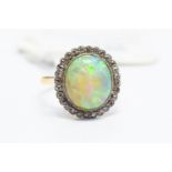 An Edwardian opal and diamond ring, comprising a large solid opal, approx 3.