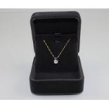 An 18ct. white gold and solitaire diamond pendant, four claw set round brilliant cut diamond, (