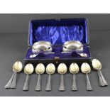 A pair of cased silver salts and set of twelve silver spoons with gilt bowl.