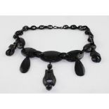 A Victorian Jet necklace of five graduated polished oval beads to the front, suspending further