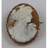 A gilt metal and shell cameo brooch, carved as a profile bust facing right of a Greco-Roman