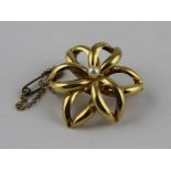 A 9ct yellow gold and pearl flower brooch, having six curved navette shaped hollow 'petals', set