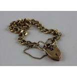 A 9ct. gold flat curb link chain bracelet with 9ct. gold heart padlock clasp, chain and clasp