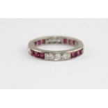A white metal, ruby and diamond eternity ring, set alternating rows of three round cut diamonds