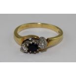 An 18ct. gold, sapphire and diamond cross-over ring, set central round cut sapphire flanked by