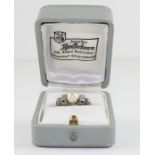 A 14ct. white gold, pearl and diamond ring, set cultured pearl to centre with pairs of round