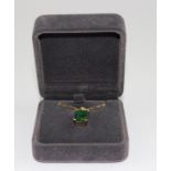 A yloow metal emerald and diamond pendant, of rectangular form, four claw set emerald-cut emerald (