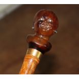 A 20th century walking cane, the handle modelled as the head of a young black child, (possibly in