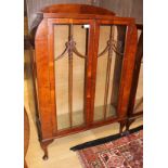 A George V Art Deco walnut veneered two door display cabinet, having two glass shelves, 124cm high,