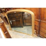 A 19th Century giltwood and gesso edged overmantle mirror, arched top scrolled brackets to base,