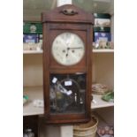 An oak 5 day, drop dial wall clock, key and pendulum, Bevelled glass front,