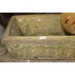 A reconstituted stone carved planter, with carved figures to each side,