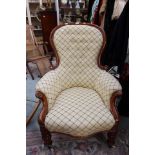 A Victorian mahogany spoon back armchair, buttoned back, turned legs, white porcelain castors,