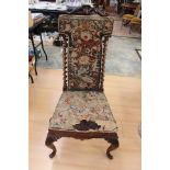 A Victorian walnut high backed chair, carved crest rail, upholstered needlework back,