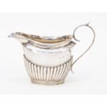 A late Victorian silver milk jug, with bright-cut engraved border above gadroon body,