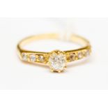 A solitaire diamond ring with shoulders set with three diamonds, total weight approx 0.