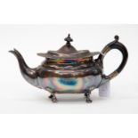 A late Victorian oval teapot, wavy rim above plain body with shell and scroll feet,