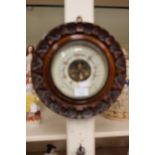 An early 20th Century hand carved mahogany cased barometer,