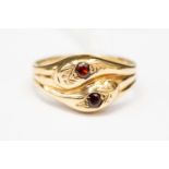 A 9ct gold duel serpent ring, each serpent head set with a garnet, size W,