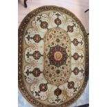 A contemporary machine made woollen rug, of oval form,