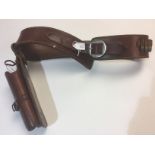 A brown leather Western style gun belt and quick draw holster. Maker marked "Taurus, Brazil".