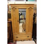 An Edwardian Art Nouveau oak wardrobe, fitted with a central mirrored door,