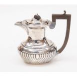 An Edwardian silver hot water jug, gadroon border and fluted body,