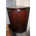 A George III mahogany hanging corner cupboard