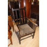 An early 20th Century wooden reclining chair with a deep seat,