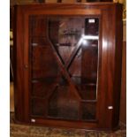 A George III mahogany hanging corner cabinet, fitted with a single glazed door,