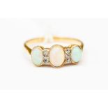 An opal and diamond ring, set with three oval opals with diamond accents, 18ct gold, size N,