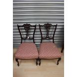 A pair of Edwardian mahogany nursing chairs, carved and pierced back splats,