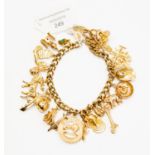 A 9ct gold charm bracelet with 9ct gold and unmarked yellow metal charms including maple leaf, stag,