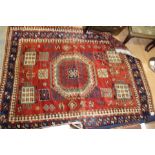 A Kazak hand knotted woollen rug, late 19th / early 20th Century, with geometric patterns in green,